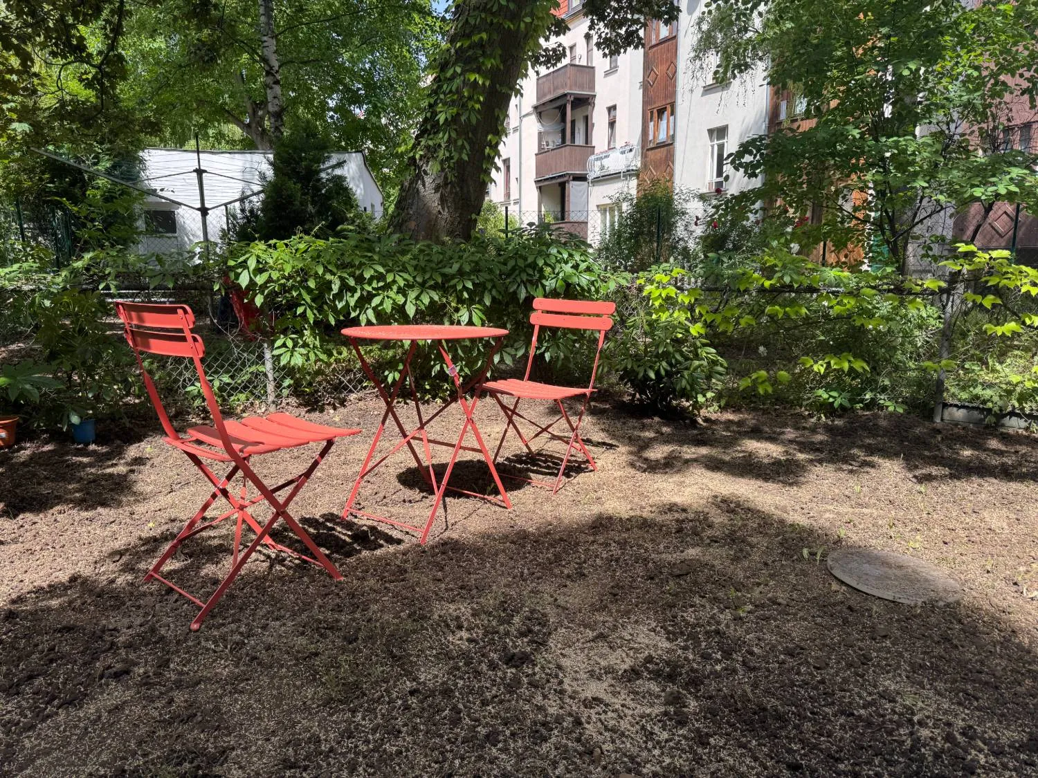 Stühle und Tisch im begrünten Innenhof