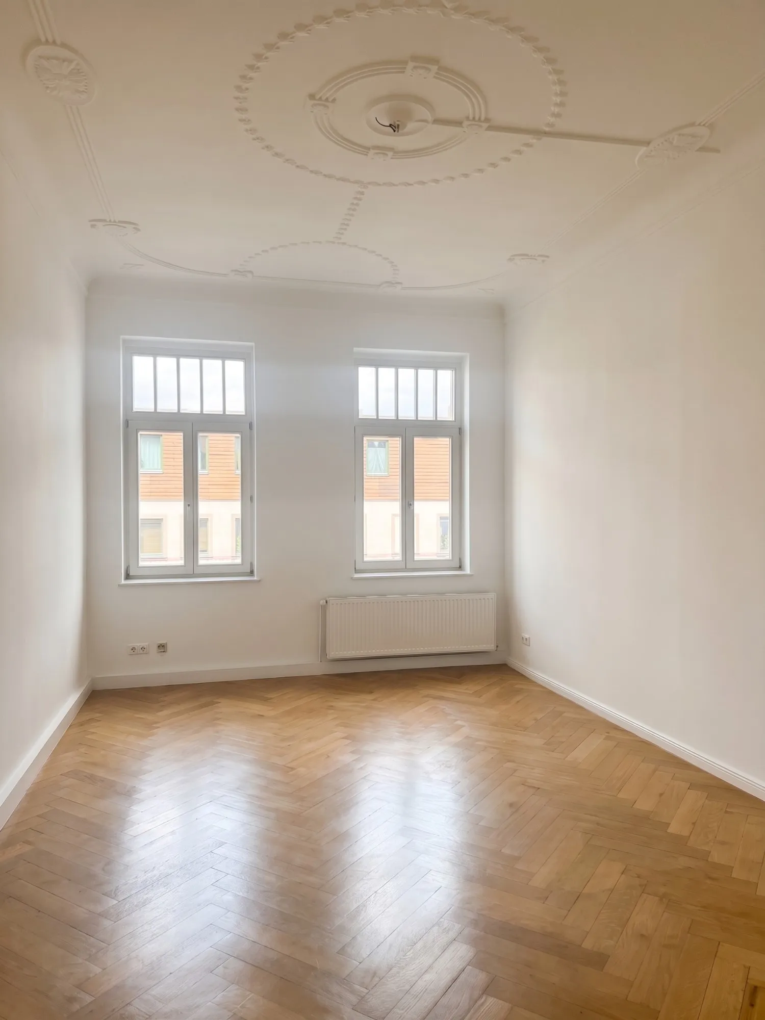 Helles Zimmer mit Stuckdecke und Fischgrätparkett